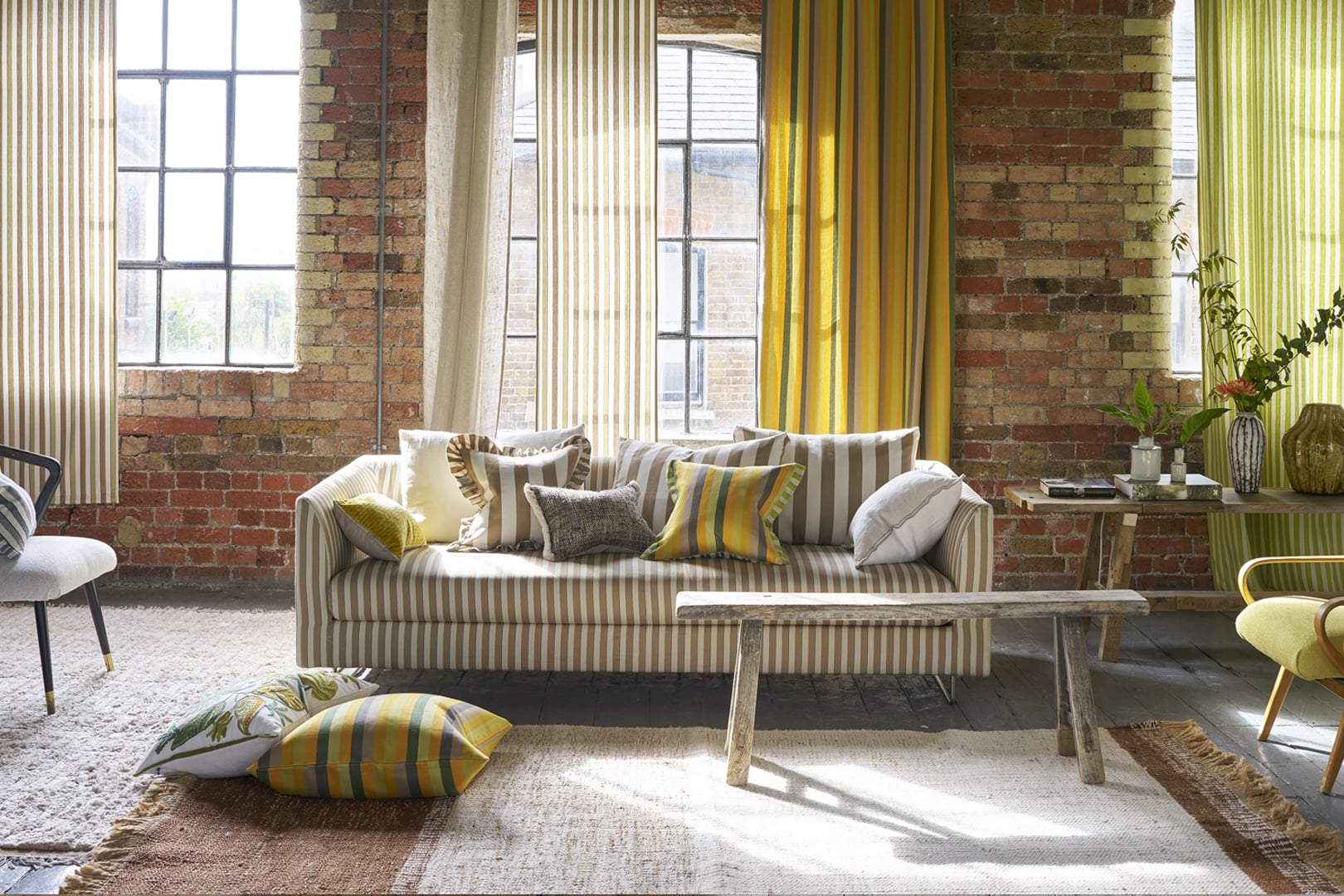 Relaxed summer interior with striped sofa, cushions and a natural woven rug