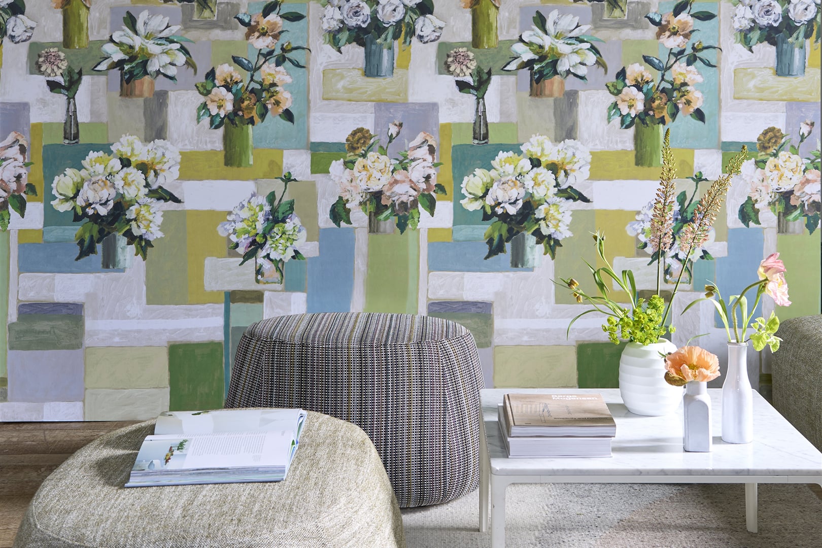 Dining room with floral wallpaper in soft blue, green and yellow tones behind upholstered chairs