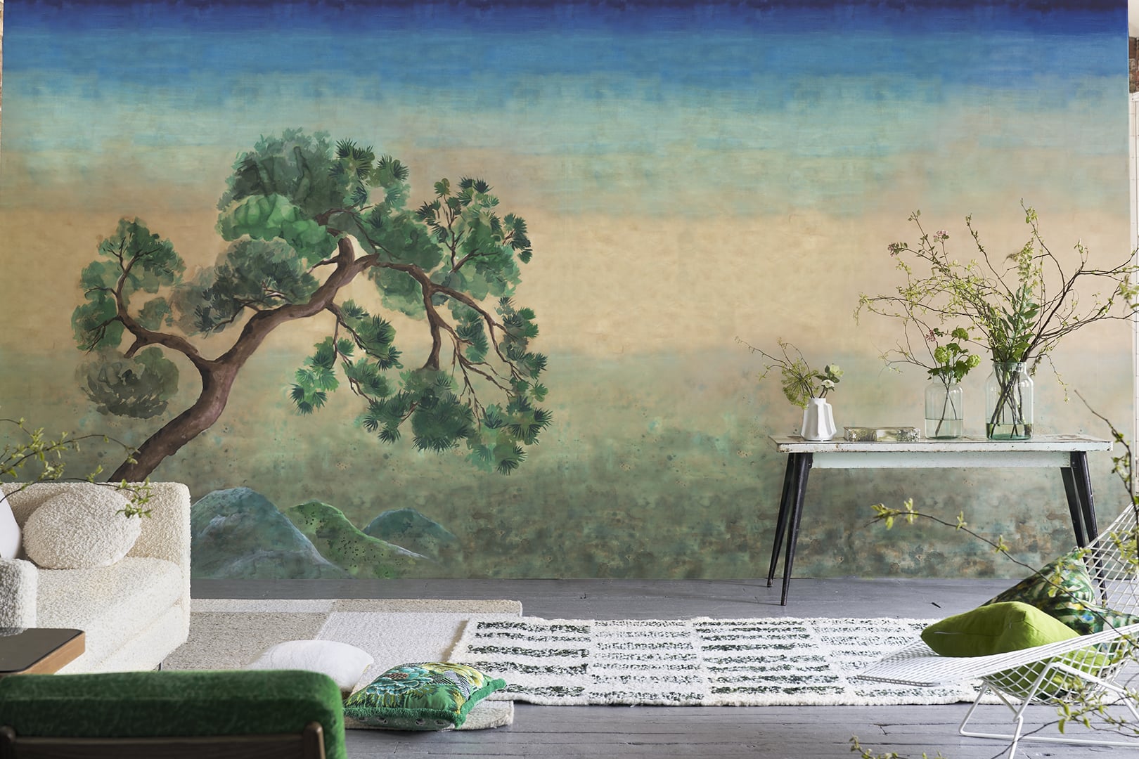 Room with scenic landscape wallpaper panel in soft blue and green tones behind a chair