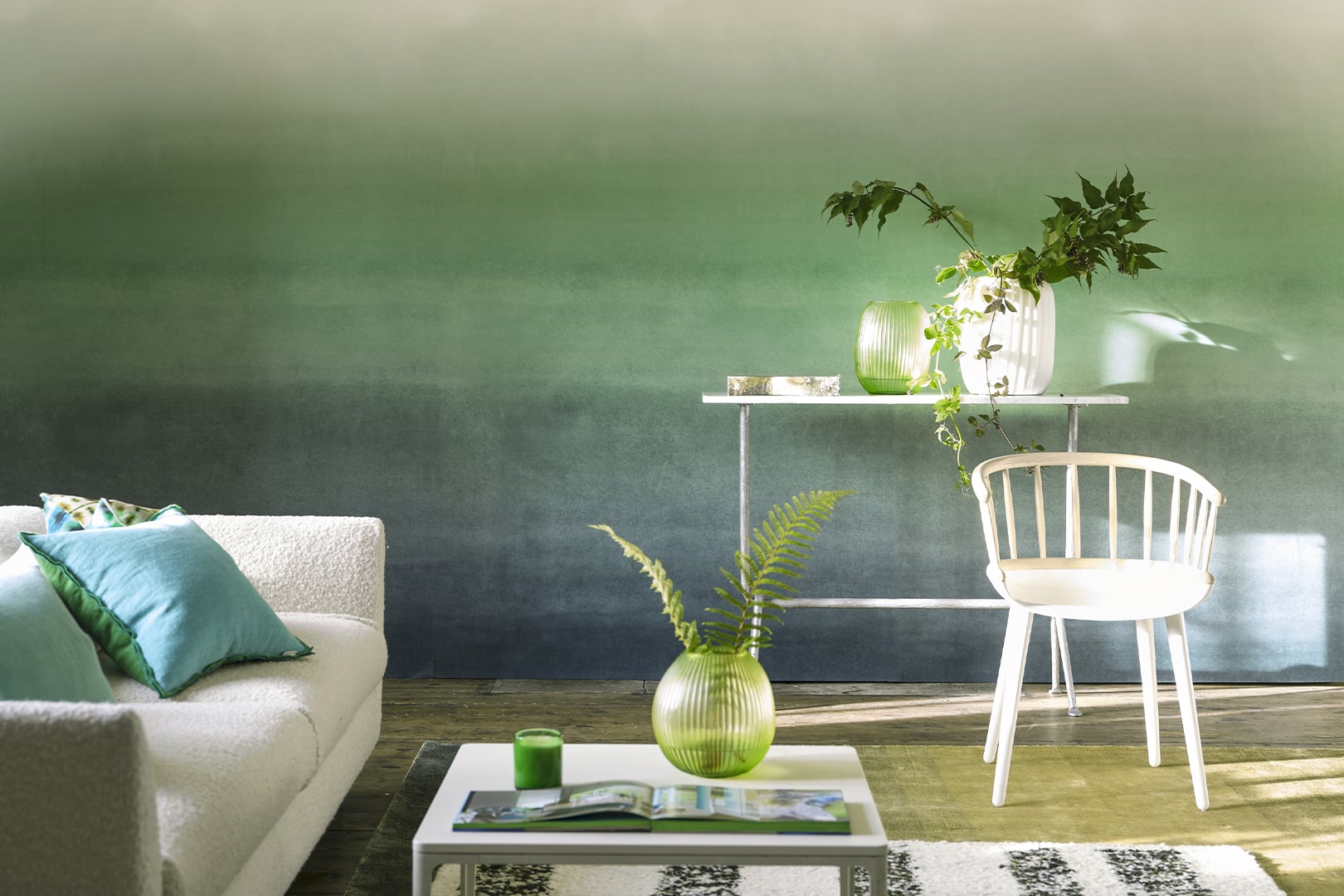 Light-filled room with plain green textured wallpaper, pale green sofa and white chair