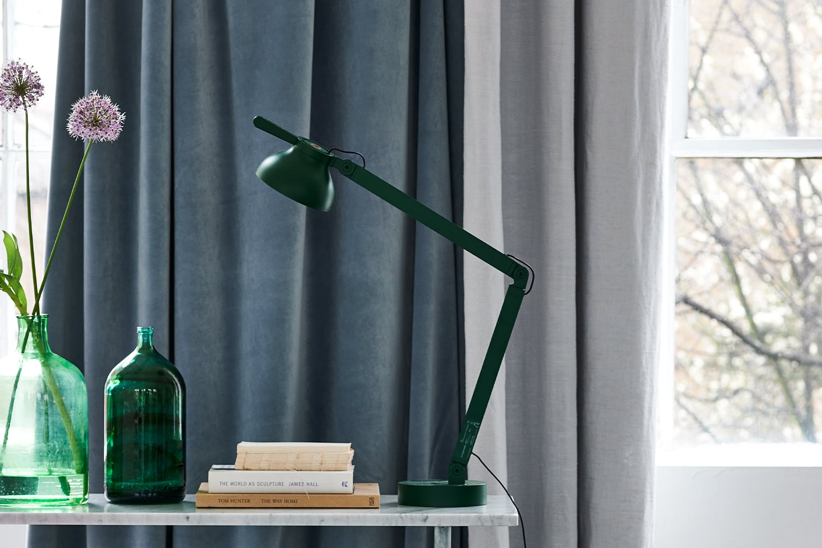 Bellagio contract curtain fabric by Designers Guild shown in layered grey drapery with contemporary green accents