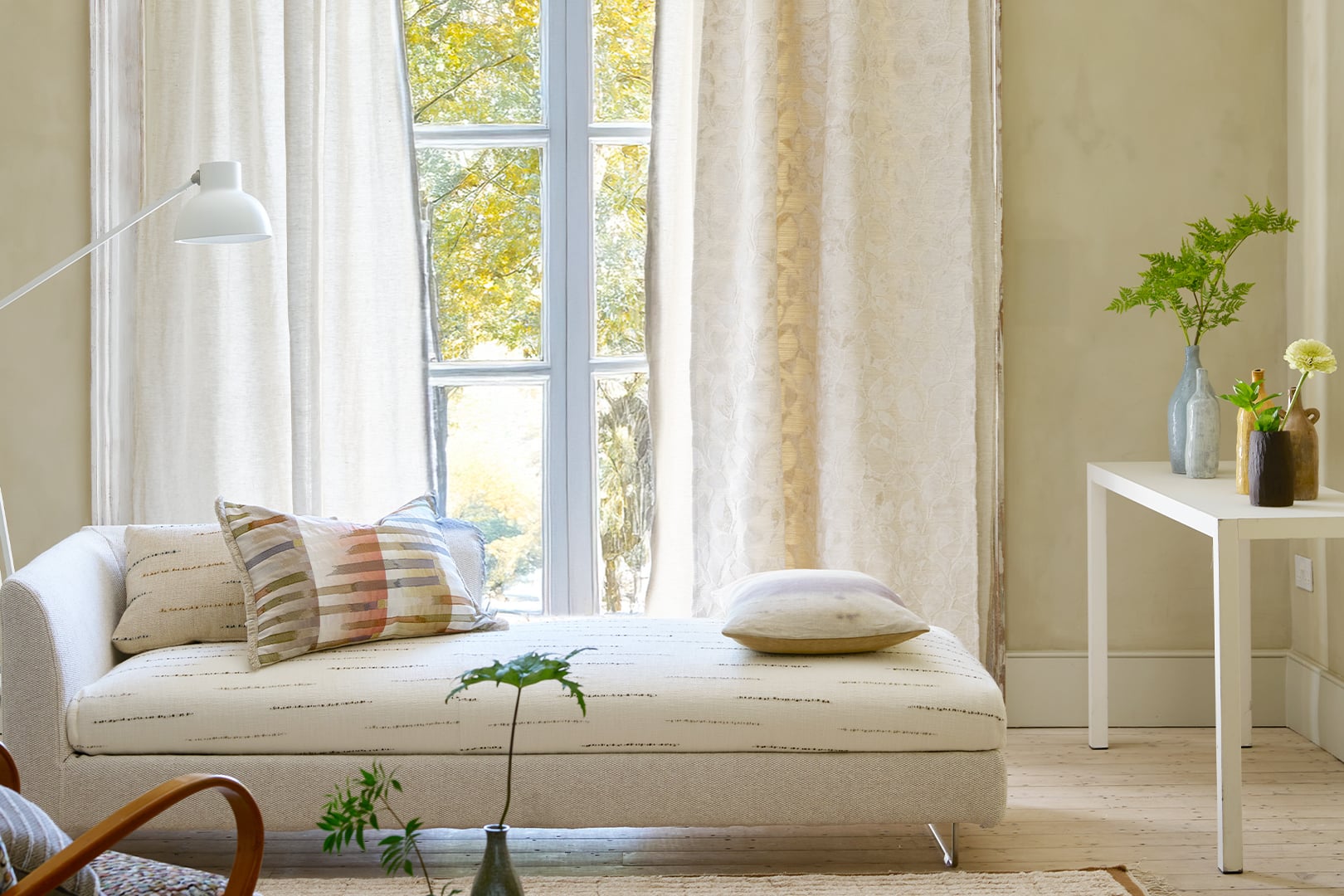 Light-filled interior with Celandine damask curtain fabric by Designers Guild in soft neutral linen tones