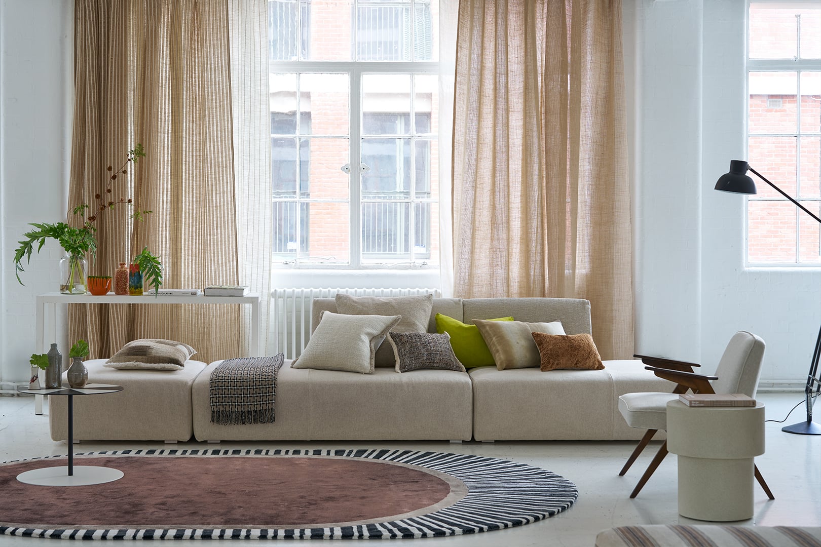 Modern living room with Isère Fabric Collection voiles and sheers by Designers Guild in soft neutral tones