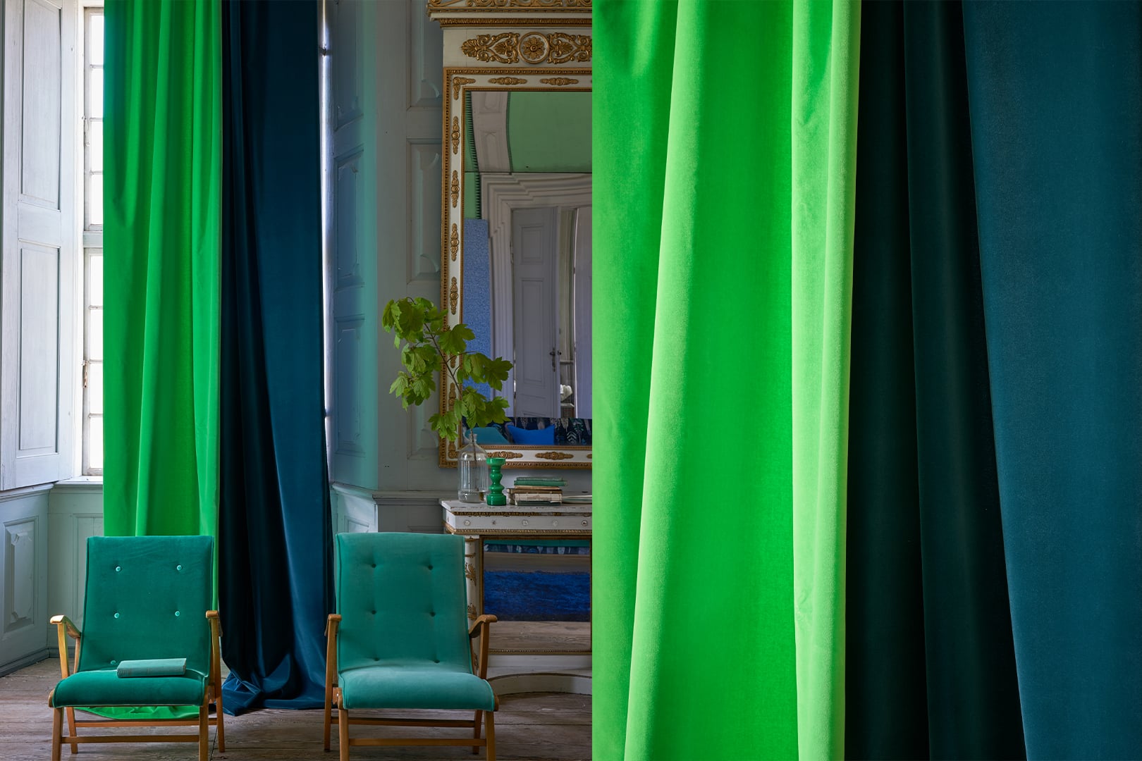 Elegant interior with Varese velvet curtains by Designers Guild in rich emerald green and deep teal tones